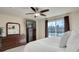 Bright bedroom featuring a large window, ceiling fan, and dark wood dresser with a TV and mirror at 6068 W Utah Ln, Lakewood, CO 80232