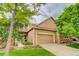 Charming two-story home featuring a manicured lawn, stone accents, and an attached two-car garage at 6068 W Utah Ln, Lakewood, CO 80232