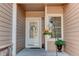 Charming front entryway features a white door with decorative wreath and beautiful flower planters by the window at 6068 W Utah Ln, Lakewood, CO 80232