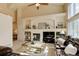 Bright living room featuring a cozy fireplace, built-in shelving, and comfortable leather seating with a ceiling fan at 6068 W Utah Ln, Lakewood, CO 80232