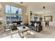 Light-filled living room with high ceilings, two leather couches, glass coffee table and adjacent dining room at 6068 W Utah Ln, Lakewood, CO 80232