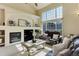 Inviting living room with a fireplace, large windows, cathedral ceiling and comfortable seating area with a ceiling fan at 6068 W Utah Ln, Lakewood, CO 80232