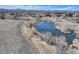 An aerial shot of a pond surrounded by grassland and trees at 6068 W Utah Ln, Lakewood, CO 80232