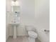 Simple half-bathroom featuring a sleek pedestal sink and a standard toilet in a clean, minimalist space at 21821 E 7Th Ave, Aurora, CO 80018