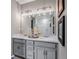 Bathroom featuring double sinks, large mirror, modern lighting, and shower at 3778 Happyheart Way, Castle Rock, CO 80109