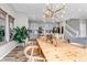 Open dining area with wood table, modern light fixture, and view into adjacent kitchen at 3778 Happyheart Way, Castle Rock, CO 80109