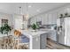 Bright kitchen featuring a large island, pendant lights, grey cabinets, and stainless steel appliances at 3778 Happyheart Way, Castle Rock, CO 80109