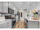 Modern kitchen with stainless steel appliances, grey cabinets, island, and wood flooring at 3778 Happyheart Way, Castle Rock, CO 80109