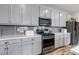 Modern kitchen features gray cabinets, stainless steel appliances, gray backsplash, and white countertops at 3778 Happyheart Way, Castle Rock, CO 80109