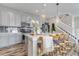 Modern kitchen with gray cabinets, quartz countertops, pendant lighting, and seating at the island at 3778 Happyheart Way, Castle Rock, CO 80109