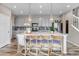 Open kitchen with pendant lights, large island, grey cabinets, and stainless steel appliances at 3778 Happyheart Way, Castle Rock, CO 80109