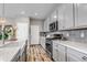 Well-lit kitchen featuring gray cabinets, stainless steel appliances, and wood-look floors at 3778 Happyheart Way, Castle Rock, CO 80109