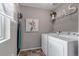 Functional laundry room with white washer and dryer, shelving, and decor at 3778 Happyheart Way, Castle Rock, CO 80109