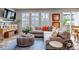 Comfortable living room features a gray sectional sofa, blue rug, shuttered windows, and curated decor at 3778 Happyheart Way, Castle Rock, CO 80109