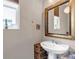 Cozy powder room featuring a stylish mirror and pedestal sink at 3778 Happyheart Way, Castle Rock, CO 80109