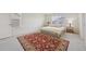 Bright bedroom featuring a bed with neutral linens, side tables and a vibrant red oriental rug at 12854 Clearview St, Firestone, CO 80504
