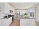 Bright kitchen features white cabinets, stainless steel appliances, and a granite island with pendant lighting at 12854 Clearview St, Firestone, CO 80504