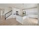 Open kitchen with white cabinets, granite countertops, stainless appliances, and island with seating, open to staircase at 12854 Clearview St, Firestone, CO 80504