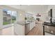 Modern kitchen featuring granite island, stainless steel dishwasher, and open layout to living area at 12854 Clearview St, Firestone, CO 80504