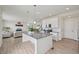 Open kitchen with island, white cabinets and stainless steel appliances, connecting to bright living room at 12854 Clearview St, Firestone, CO 80504