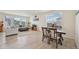Open-concept living area with a dining table, hardwood floors, and plenty of natural light at 12854 Clearview St, Firestone, CO 80504