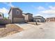 View of the back of townhomes, each featuring a garage and driveway at 15957 E Elk Pl, Denver, CO 80239