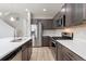 Modern kitchen with stainless steel appliances, quartz countertops, and dark wood cabinets at 15957 E Elk Pl, Denver, CO 80239