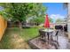 Well-maintained backyard with a patio, seating, lush lawn, and mature trees at 12261 N Holly Way, Brighton, CO 80602