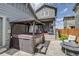 Backyard with a hot tub, gazebo, string lights, and patio with lounge seating near the outdoor fire pit at 8444 E 55Th Pl, Denver, CO 80238