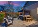 Relaxing backyard oasis featuring a hot tub, a cozy fire pit, a small table, and comfortable seating at 8444 E 55Th Pl, Denver, CO 80238
