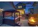 Backyard view showcasing a hot tub, fire pit, ambient lighting, and a view of the home's exterior at 8444 E 55Th Pl, Denver, CO 80238
