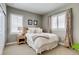Comfortable bedroom with a bed, a nightstand, two windows with shutters, and light colored walls at 8444 E 55Th Pl, Denver, CO 80238
