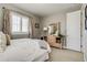 Bedroom with neutral paint, shutters, dresser with mirror, and luxurious bedding at 8444 E 55Th Pl, Denver, CO 80238