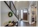 Welcoming entryway with hardwood floors, decorative wreath, and staircase with black iron railing at 8444 E 55Th Pl, Denver, CO 80238
