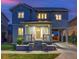 Charming two-story home featuring a welcoming front porch and well-maintained lawn with a carport at dusk at 8444 E 55Th Pl, Denver, CO 80238