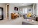 Cozy living room featuring a piano, gray sofa with yellow pillows, and natural light from the window at 8444 E 55Th Pl, Denver, CO 80238