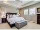 Bright main bedroom with white linens, tray ceiling, ceiling fan, and shuttered windows at 8444 E 55Th Pl, Denver, CO 80238