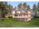 Beautiful multi-story home featuring a turret, covered porch, and lush green lawn at 407 S White Tail Dr, Franktown, CO 80116