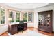 Bright office with a large desk, built-in shelving, and a view of the surrounding woods at 407 S White Tail Dr, Franktown, CO 80116