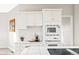 Well-lit kitchen with white cabinets, tile countertops, and modern appliances at 407 S White Tail Dr, Franktown, CO 80116
