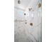 Large walk-in shower with marble tile and multiple shower heads at 5363 Quail St, Arvada, CO 80002