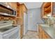 Functional kitchen with light wood cabinets, neutral countertops, tile backsplash, and modern appliances at 2227 Canyon Blvd # 312A, Boulder, CO 80302