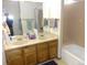 Bright bathroom with double sinks, granite countertops, and tile shower, designed for comfort and convenience at 11772 E Adriatic Pl, Aurora, CO 80014