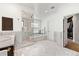 Luxurious bathroom boasts glass shower and soaking tub surrounded by marble tile and walk-in closet at 1027 S Fillmore Way, Denver, CO 80209
