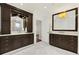 Spacious bathroom featuring dark wood cabinetry, double sinks, marble countertops, and tile flooring at 1027 S Fillmore Way, Denver, CO 80209