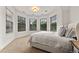 Bright bedroom featuring three large windows and a bed with white linens and fluffy pillows at 1027 S Fillmore Way, Denver, CO 80209
