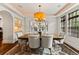 Dining room boasts an exquisite chandelier, hardwood floors, and ample light for an inviting atmosphere at 1027 S Fillmore Way, Denver, CO 80209