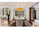 Elegant dining room with hardwood floors, large windows, and a statement chandelier above a wood dining table at 1027 S Fillmore Way, Denver, CO 80209