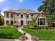 Elegant home featuring a beautiful front yard, manicured landscaping, and a charming walkway at 1027 S Fillmore Way, Denver, CO 80209