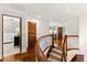 Hallway with wood floors, a curved staircase and an open view into a blue wallpapered room at 1027 S Fillmore Way, Denver, CO 80209